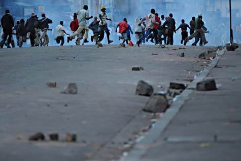Partisans d’Andry Rajoelina, maire d’Antananarivo, fuyant les tirs de gaz lacrymogène, après une confrontation entre manifestant